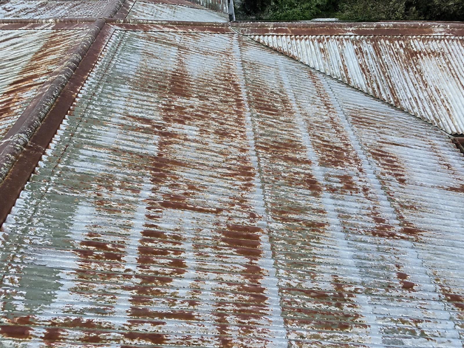Altes Metalldach mit Rost und abblätternder Farbe vor der Sanierung